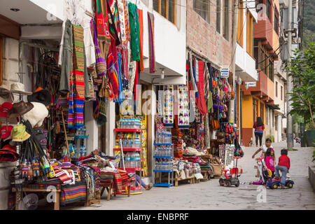 Souvenirläden und Kinder spielen auf Gehweg in Machu Picchu Pueblo, Peru. Stockfoto