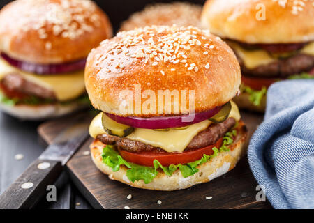 Leckere Burger mit Rindfleisch, Speck, Käse und Gemüse Stockfoto