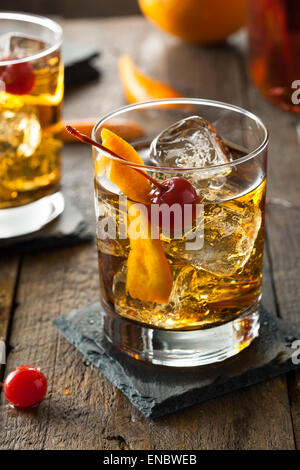 Hausgemachte Old Fashioned Cocktail mit Kirschen und Orangenschale Stockfoto