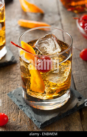 Hausgemachte Old Fashioned Cocktail mit Kirschen und Orangenschale Stockfoto