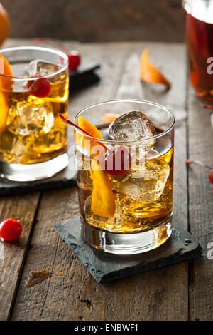 Hausgemachte Old Fashioned Cocktail mit Kirschen und Orangenschale Stockfoto