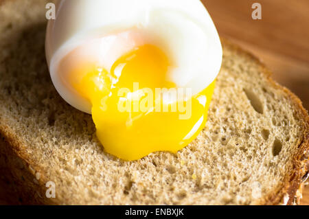 Das Eigelb fließt von gekochtes Ei auf toast Stockfoto