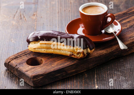 Kaffee und Schokolade Eclair Tasse auf dunklem Holz Stockfoto