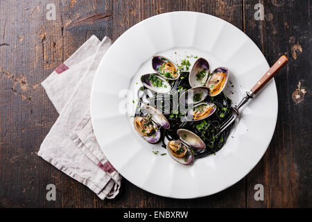 Pasta mit Meeresfrüchten mit Venusmuscheln Spaghetti Vongole auf weißen Teller auf dunklem Marmor Stockfoto