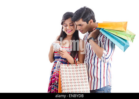 2 indische Shopping Paare verheiratet und SMS lesen Stockfoto