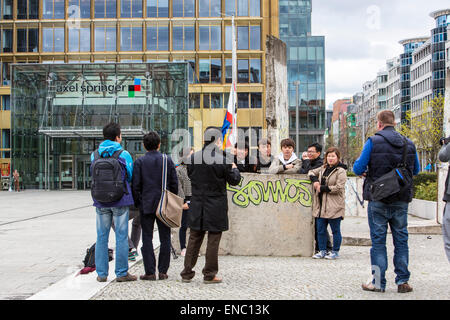 Touristen fotografieren mit Resten der Berliner Mauer, vor der Verlag Axel Springer Verlag, Berlin, Deutschland Stockfoto
