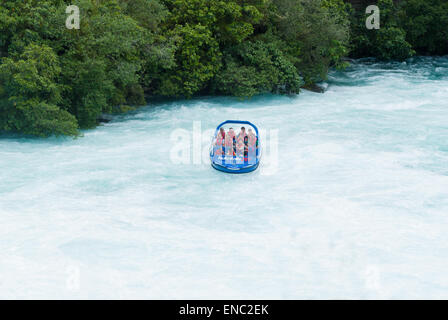 Touristen in einem Jet-Boot genießen den Anblick der tosenden Stromschnellen an den Huka Falls am Waikato River Taupo Nordinsel Neuseeland Stockfoto