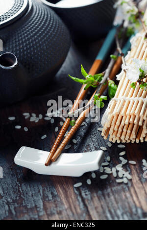 Chinesische Tee-Set, Stäbchen und Sakura Zweig am rustikalen Holztisch Stockfoto