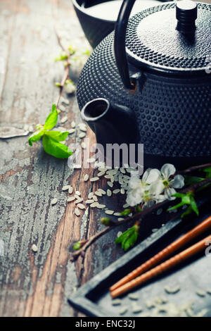 Chinesische Tee-Set, Stäbchen und Sakura Zweig am rustikalen Holztisch Stockfoto