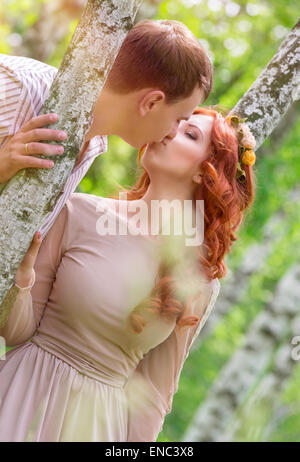 Sanfte junge Brautpaar küssen im Park, zwischen zwei wunderschönen Birke feiern Hochzeitstag Stockfoto