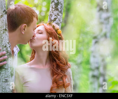 Sanfte junge Brautpaar küssen im Park, zwischen zwei wunderschönen Birke feiern Hochzeitstag Stockfoto