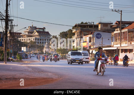 Motorräder sowie vier Fahrzeuge in den Abend-Verkehr auf der Straße 13 in Pakse, Laos. Stockfoto