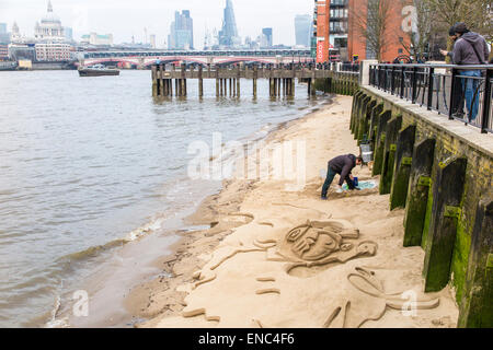 Sand Bildhauer Figuren in den Sand auf einer Sandbank am Fluss bei Ebbe für Tipps, auf der South Bank, Themse, London SE1 Stockfoto