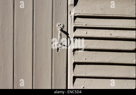 Detail der alte weiße Holztür mit Verriegelung Griff am Nebengebäude in Suffolk, England, UK Stockfoto