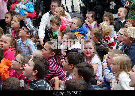 Kinder sitzen auf dem Boden eine Punch und Judy Show auf dem International Puppet Festival in Witham, Essex Stockfoto