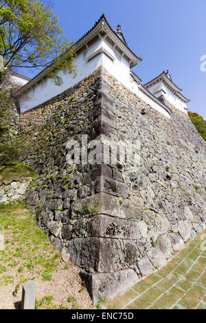 Niedriger Winkel Blick auf die Ecke Taikaku yagura, Turm, mit Eckstein Fallloch auf der Ishigaki Steinmauer, auf Himeji Burg. Stockfoto