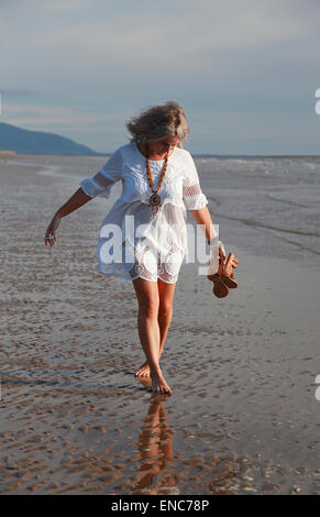 Blonde kurzhaarige Frau barfuß am Strand Stockfoto