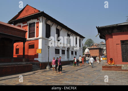 Einheimische gehen durch den Pashupatinath Hindu-Tempelkomplex in Kathmandu, Nepal, erbaut im Pagodenstil und aus dem 5. Jahrhundert. Stockfoto