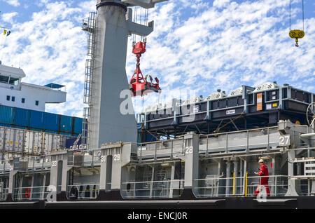 Seemann zu Fuß auf einem Frachtschiff ein Kran Container im Hafen von Cape Town, Südafrika wird geladen Stockfoto