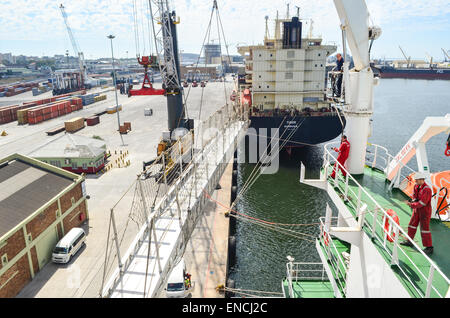 Seeleute in einem Frachtschiff, heben Sie die Gangway im Hafen von Kapstadt, Südafrika Stockfoto