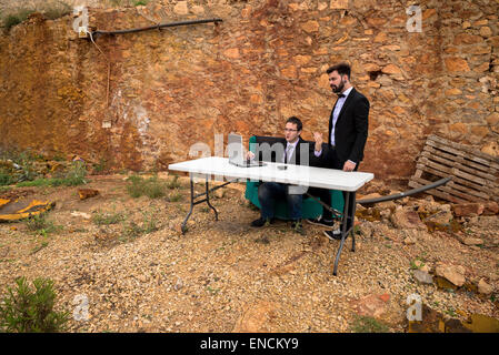 Zwei junge Männer in einem Grunge-Büro, ein Krisenkonzept arbeiten Stockfoto