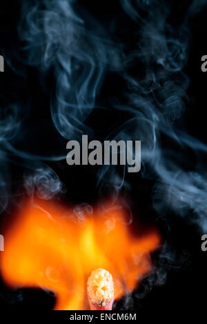 Leiter der ein Streichholz zwischen der Flamme und der Rauch, der zieht ein Gesicht wie ein Gespenst Stockfoto