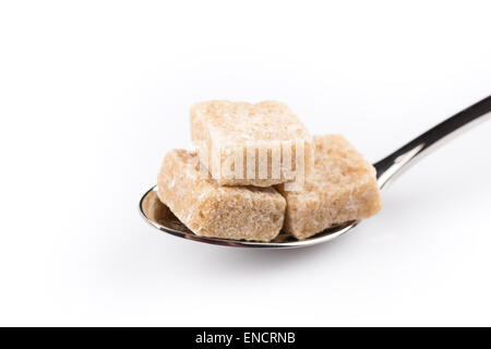 Würfel aus braunem Zucker auf einem Metalllöffel isoliert Stockfoto