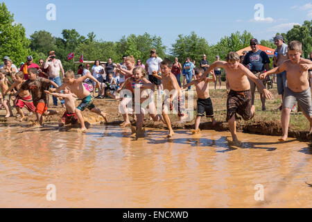 Augusta, Georgia, USA. 2. Mai 2015. Junge Kinder springen in einem schlammigen Wasserloch der 2015 rot Hals Meisterschaften 2. Mai 2015 in Augusta, Georgia. Hunderte von Menschen kam einen Tag an Land Sport und Aktivitäten. Stockfoto