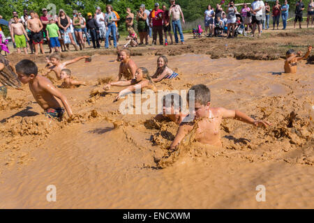 Augusta, Georgia, USA. 2. Mai 2015. Junge Kinder springen in einem schlammigen Wasserloch der 2015 rot Hals Meisterschaften 2. Mai 2015 in Augusta, Georgia. Hunderte von Menschen kam einen Tag an Land Sport und Aktivitäten. Stockfoto