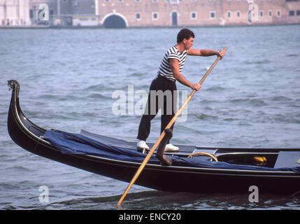 Venedig, Provinz Venedig, Italien. 1. September, 1985. Trägt ein traditionelles gestreiftes Hemd, ein Gondoliere Pole eine klassischen Gondel in den Bacina San Marco (St. Marks Becken). Venedig, ein UNESCO-Weltkulturerbe zählt zu den beliebtesten internationalen Reisezielen. © Arnold Drapkin/ZUMA Draht/Alamy Live-Nachrichten Stockfoto