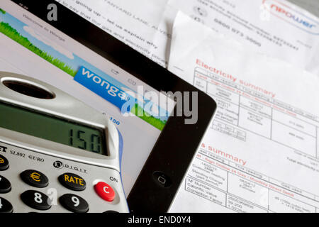 Wonga Darlehen Unternehmens-Website auf einem Ipad mit Taschenrechner und Utility Bills, England, UK Stockfoto