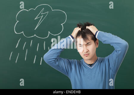 Ein Kerl mit einer schlechten Stimmung, gezeichnet auf einer Cloud von Blackboard und Regen Stockfoto