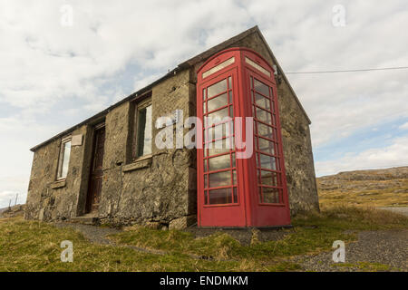 Eine alte Post mit einer leuchtend rote Telefonzelle daneben auf der Isle of Harris, Schottland Stockfoto