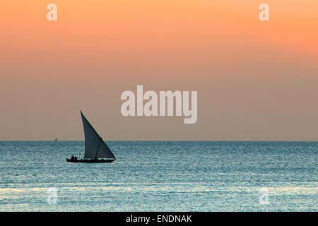 Silhouette von einem kleinen Segelboot (dau) auf Wasser bei Sonnenuntergang, Sansibar Stockfoto