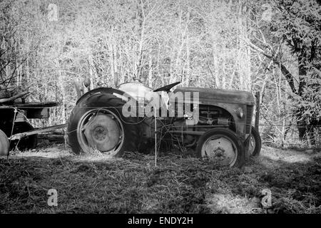 eine alte Traktor verlassen in einem Feld in schwarz und weiß Stockfoto