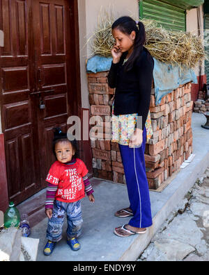 Lalitpur, Nepal. 3. Mai 2015. Ein Mädchen am Telefon während ihrer jüngeren Schwester in ihrem Haus in der Nähe spielen. Die 2015 Erdbeben in Nepal, die mehr als 7.000 Menschen getötet und verletzt mehr als doppelt so viele, am 25 April, der Moment-Magnitude 7.8. Es war die stärkste Katastrophe Streikrecht Nepal seit 1934 Nepal – Bihar Erdbeben. © Prabhat Kumar Verma/Pacific Press/Alamy Live-Nachrichten Stockfoto