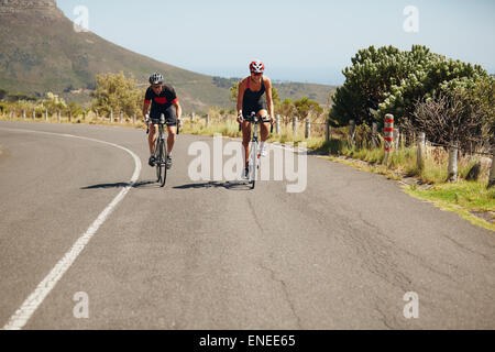 Radsportler, die Fahrräder auf offener Straße. Triathleten auf Fahrrädern Radfahren. Üben für Triathlon-Rennen. Stockfoto