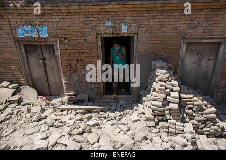 Kathmandu, Nepal. 3. Mai 2015. Eine Frau wird von ihrem beschädigten Haus verlassen, wo Trümmern überall herum in das kleine Dorf Sankhu außerhalb Kathmandu. Nepalese Erdbeben-Überlebenden außerhalb Khatmandu warten noch mehr Zubehör und Hilfe aus der rettet, mehr als eine Woche nach dem tödlichen Erdbeben, die mehr als 7000 Menschen in Nepal, um 14000 verletzte und mehr als 500000 obdachlose Menschen zu töten. © Guillaume Payen/ZUMA Wire/ZUMAPRESS.com/Alamy Live-Nachrichten Stockfoto