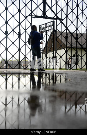 Dachau, Deutschland. 5. Mai 2015. Ein Mann nimmt ein Bild einer eingeschriebenen Tür mit dem Wort "Arbeit Macht Frei" (lit.) Arbeit bringt Freiheit) am Eingang zum ehemaligen KZ Dachau in Dachau, Deutschland, 05. Mai 2015. Russische Biker sind Gruppe "Night Wolves" auf einer selbsternannten Sieg-Tour von Moskau nach Berlin, um den 70. Jahrestag des Endes des zweiten Weltkriegs markieren. Laut einem Sprecher des Vereins plant der Verein Gedenkstätte Dachau nach einem Zwischenstopp in München zu besuchen. Night Wolves' Tour wurde von der deutschen Regierung kritisiert. Foto: Andreas Gebert/Dpa/Alamy Live-Nachrichten Stockfoto