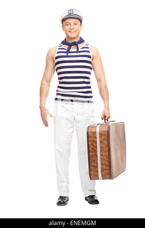 In voller Länge Portrait eines schönen jungen Matrosen halten eine braune Tasche und schaut in die Kamera, die isoliert auf weißem Hintergrund Stockfoto