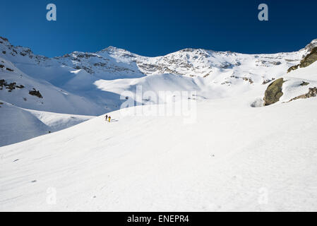 Paar Alpinist Wandern bergauf von Skitouren auf verschneiten Hang auf den Gipfel des Berges in einem sonnigen Tag des Frühlings. Stockfoto