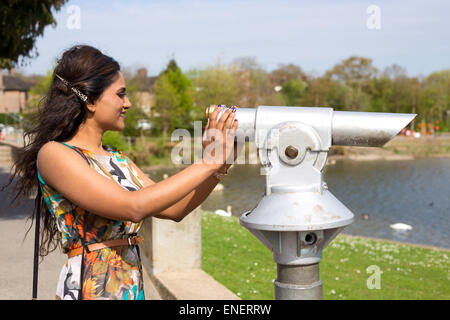 eine junge Frau mit einem Blick durch ein Teleskop Stockfoto