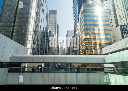 Abstrakte futuristische Stadtbild Ansicht mit modernen Wolkenkratzern und Menschen zu Fuß auf die Brücke. Hong Kong Stockfoto