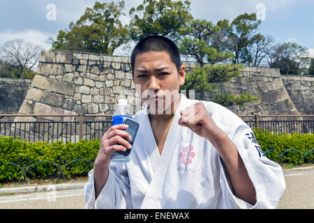 Japanischer Jugendlicher in Karate Kämpfer Stellung. Er steht auf der Straße ist, tragen Kimonos und posieren Stockfoto
