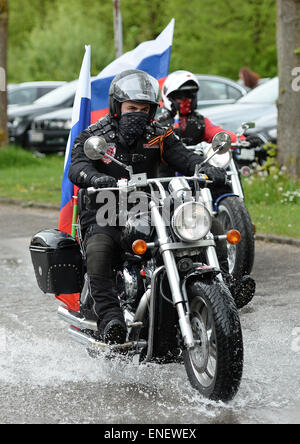 Dachau, Deutschland. 4. Mai 2015. Ein Anhänger der russischen Biker Club "Night Wolves" trägt eine russische Flagge auf seinem Motorrad fährt er über die Besucher-Parkplatz an der KZ-Gedenkstätte Dachau in Dachau, Deutschland, 4. Mai 2015. Die Gruppe begann seine Tour 25 April in Moskau und will es in Berlin Sonntag, 10 Mai, am Ende der Tag des Sieges in Russland ist, der Tag jedes Jahr, es erinnert an die Kapitulation der Nazis zu sowjetischen, Truppen im zweiten Weltkrieg. Bildnachweis: Dpa picture Alliance/Alamy Live News Stockfoto