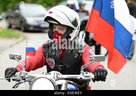 Dachau, Deutschland. 4. Mai 2015. Ein Anhänger der russischen Biker Club "Night Wolves" trägt eine russische Flagge auf seinem Motorrad fährt er über die Besucher-Parkplatz an der KZ-Gedenkstätte Dachau in Dachau, Deutschland, 4. Mai 2015. Die Gruppe begann seine Tour 25 April in Moskau und will es in Berlin Sonntag, 10 Mai, am Ende der Tag des Sieges in Russland ist, der Tag jedes Jahr, es erinnert an die Kapitulation der Nazis zu sowjetischen, Truppen im zweiten Weltkrieg. Bildnachweis: Dpa picture Alliance/Alamy Live News Stockfoto