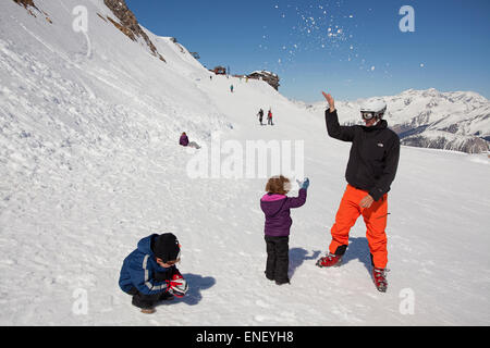 Vater und Kinder spielen im Schnee Stockfoto