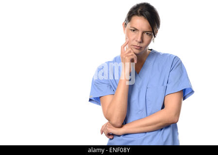 Mutlos junge Ärztin oder Krankenschwester tragen blaue chirurgische Peelings starrte mürrisch auf den Boden mit einem nachdenklichen Ausdruck ist Stockfoto