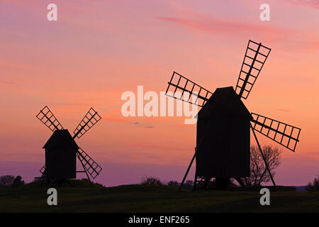 Zwei traditionelle Windmühlen bei Resmo Silhouette gegen Sonnenuntergang auf der Insel Öland, Schweden Stockfoto