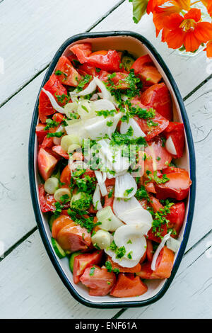 Tomatensalat mit Zwiebel und Petersilie in einem Metalltablett Stockfoto